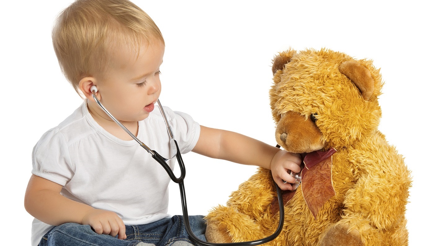 Toddler using a stethoscope on a teddy bear
